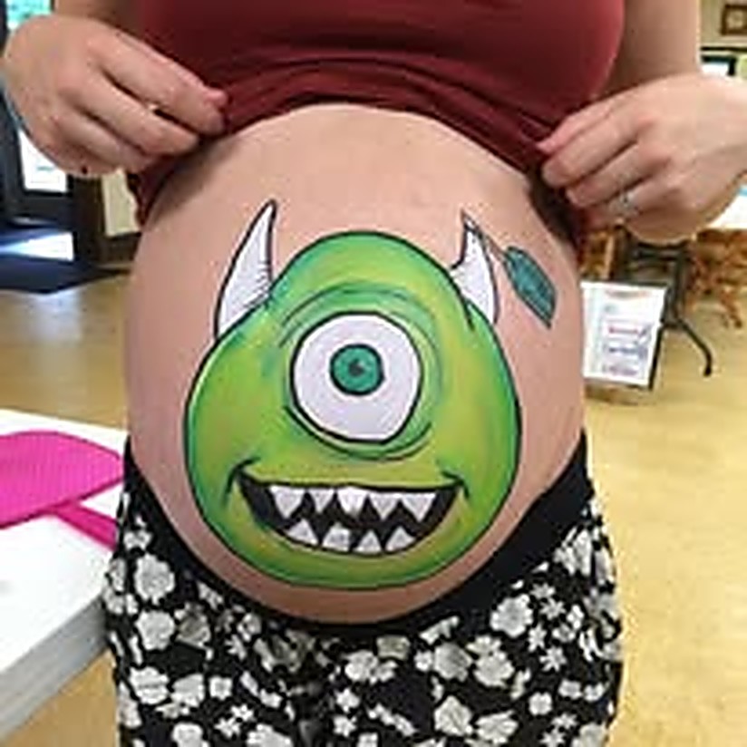 Baby bump painted as a friendly green monster